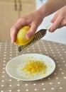 Woman rubbing lemon zest on grater Royalty Free Stock Photo