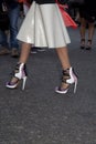 A closeup of a woman`s designer heels on the street