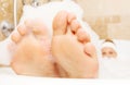 Closeup of woman`s feet covered with foam bubble bath