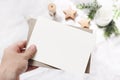 Closeup of woman`s hand holding blank paper card. Greeting card mock-up scene. Chritsmas winter design. Feminine styled Royalty Free Stock Photo