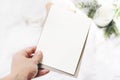 Closeup of woman`s hand holding blank vertical paper card. Greeting card mock-up scene. Chritsmas winter design Royalty Free Stock Photo