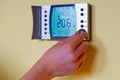 Closeup of a womans hand setting the room temperature on a mode Royalty Free Stock Photo