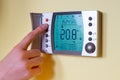 Closeup of a womans hand setting the room temperature on a mode