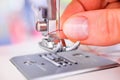 Woman`s hand threading sewing machine needle Royalty Free Stock Photo