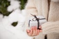 Closeup of woman`s hands holding a nice Christmas present. Outdoors. Celebration. Holidays, gifts and winter concept
