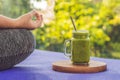 Closeup of a woman`s hands during meditation with a green smoothies of spinach, orange and banana Royalty Free Stock Photo