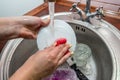 Close up woman`s hands of washing dishes in kitchen sink. Cleaning chores Royalty Free Stock Photo