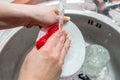 Close up woman`s hands of washing dishes in kitchen sink. Cleaning chores Royalty Free Stock Photo