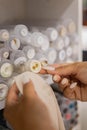 Closeup woman seamstress hands choosing button stud to tissue sample at store. Dressmaking Royalty Free Stock Photo