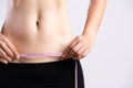 Closeup of woman showing on her belly dark scar from a cesarean section with measuring tape. Healthcare concept Royalty Free Stock Photo