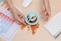 Closeup of woman spilled coffee on office desk, top view Royalty Free Stock Photo