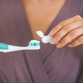 Closeup on young woman squeezing toothpaste on toothbrush Royalty Free Stock Photo