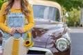 Woman in jean overalls holding sunflowers by antique pickup truck Royalty Free Stock Photo