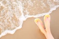Closeup of woman  stylish flip flops on sand near sea, space for text. Beach accessories Royalty Free Stock Photo