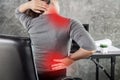 Woman suffering from office syndrome having lower back pain, neck and shoulder pain sitting on chair Royalty Free Stock Photo