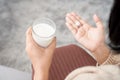 woman taking medicine hand holding a glass of milk