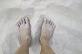 Closeup of woman tanned barefoot standing on white sand beach. Travel concept. Happy feet in tropical paradise Royalty Free Stock Photo