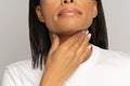 Closeup of woman touch sore throat. African female suffer from swallowing difficulty, angina or cold