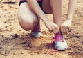 closeup of woman tying shoe laces. Female sport fitness runner getting ready for jogging outdoors on forest path i Royalty Free Stock Photo