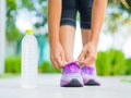 Closeup of woman tying shoe laces. Female sport fitness runner getting ready for jogging with water bottle Royalty Free Stock Photo