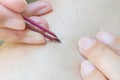 Closeup asian woman use tweezer for plucking hairy leg