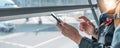 Closeup of a woman using a cell phone at the airport, taking photos or researching travel information. Royalty Free Stock Photo