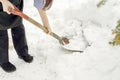 Closeup woman using shovel scoop and cleared heap snow on floor after heavy snow fall last night