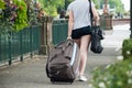 woman walking in the street with suitcase and jeans s