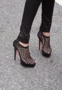 A closeup of a woman wearing black high heels on the street