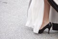 A closeup of a woman wearing black high heels on the street