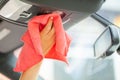 Closeup of woman wiping car interior with red rag