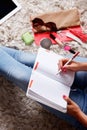 Closeup of a woman writing into her desk diary