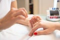 Closeup of a woman's hand in a nail salon receiving a manicure by a beautician with nail file Royalty Free Stock Photo