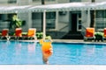 Closeup woman's hand sticking out of swimming pool holding tropical cocktail. Cropped girl's female's hand Royalty Free Stock Photo