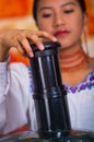 Closeup woman's hands using juice maker, pressing down plastic part inserting carrot into machine, healthy lifestyle