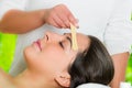 Closeup womans face receiving facial hair waxing treatment, hand using wooden stick to apply wax, beauty and fashion Royalty Free Stock Photo