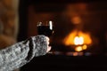 Woman sitting by fieldstone fireplace with glass of wine Royalty Free Stock Photo