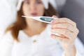 Closeup of womans hand with a medical thermometer with very high body temperature. Fever. Young sick woman checking her body