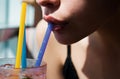 Closeup of womans lips drinking with pink straw. Woman drink cocktail. Close up wet sexy lips. Royalty Free Stock Photo