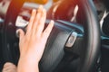 Closeup women driver hand at steering wheel horn