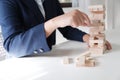 Closeup of women playing wood blocks stack game, concept of business growth, glambling, risk