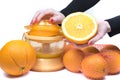 Closeup on womenÃ¢â¬â¢s hand making orange juice. Electric press juicer with cut orange isolated on white background Royalty Free Stock Photo