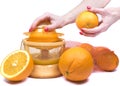 Closeup on womenÃ¢â¬â¢s hand making fresh orange juice. Electric press juicer with cut orange isolated white background Royalty Free Stock Photo