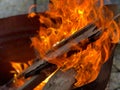 Closeup of a wood burning in fire flames in a rusty metallic pot