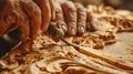 Closeup of wood carver hand making sculpture with chisel