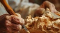 Closeup of wood carver hand making sculpture with chisel