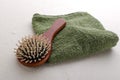 Closeup of green towel and wooden hair brush on the wet surface