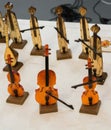 Closeup of wooden cello miniatures on the table with other musical instruments on the background
