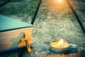 Closeup of wooden Christian cross on bible, burning candle on the old table. Royalty Free Stock Photo