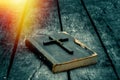 Closeup of wooden Christian cross on bible on the old table. Royalty Free Stock Photo